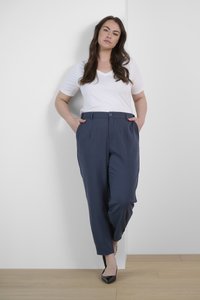 Pantalones marinos de pierna recta, con bolsillos laterales y cierre de un solo botón. Combinados con una camiseta blanca de escote en V y tacones negros.