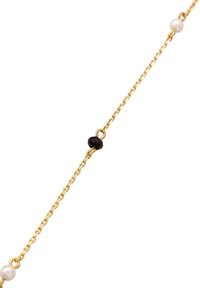 Collana in oro con perle bianche tonde e una perla nera sfaccettata, che presenta un design delicato e una texture liscia.