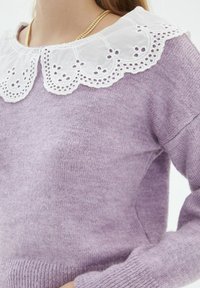 Maglione lilla in maglia con un colletto di pizzo bianco decorativo caratterizzato da bordi ondulati e motivi a occhio. Texture morbida, maniche lunghe e orlo a costine.