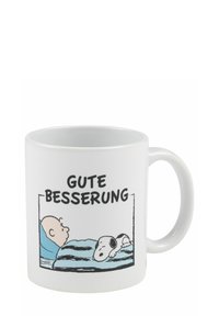 Tazza in ceramica bianca con un'immagine caricaturale di un personaggio a letto con un cane, con il testo "GUTE BESSERUNG" sopra.