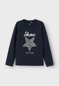 Marineblaue Langarmshirt mit rundem Ausschnitt. Mit einer Sterne-Grafik aus silbernen Punkten und dem Text "Shine like a star" in Weiß.