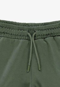 Groene katoenen joggingbroek met een elastische tailleband met een geplooid textuur en een trekkoord. Glad materiaal, eenvoudig ontwerp, geen patronen.