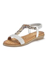 Silberne geflochtene Sandalen verfügen über eine strukturierte braune Innensohle, einen elastischen Riemen an der Rückseite und eine flache Sohle mit einem goldenen Akzent.