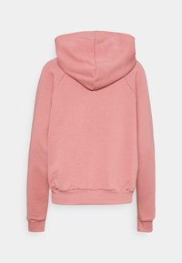 Sweat à capuche rose clair, fabriqué en tissu doux, avec des poignets et un ourlet côtelés, une texture lisse et sans motifs visibles.