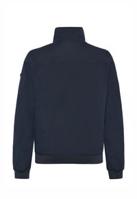 Laivastonsininen bomber-takki, jossa on pystykolmioinen kaulus, resorit hihansuissa ja helmassa sekä sileä, mattapintainen tekstuuri. Ei näkyviä kiinnityksiä tai koristuksia.