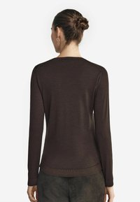 Brun långärmad tröja i mjukt material, med rund halsringning och ribbstickade ärmslut, med en slät struktur och figurnära design.