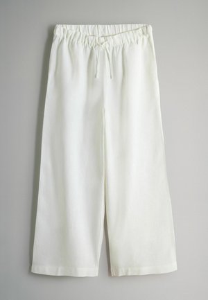 White linen culottes with an elastic waistband and drawstring, featuring a relaxed fit and knee-length design. Smooth texture and lightweight.