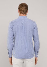 Camicia a maniche lunghe a righe blu e bianche con colletto button-down, vestibilità sartoriale, dotata di piega sul retro e orlo arrotondato.