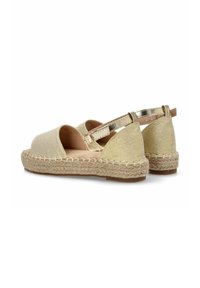 Sandalias de esparto doradas con acabado textil, diseño de punta abierta, suela intermedia de yute y detalle de tira metálica en el tobillo. Suela plana para mayor comodidad.