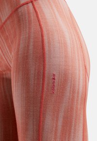 Orange atletiske leggins med et subtilt stribet mønster og pink syninger. Brandlogoen er synlig på siden. Blødt, strækbart stof.