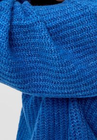 Sciarpa blu lavorata a maglia con una texture morbida, caratterizzata da un motivo a lavorazione larga e un colore uniforme su tutta la lunghezza. Le estremità pendono verso il basso.