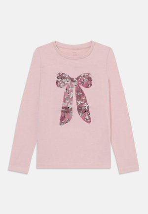 Long-sleeve pink cotton shirt with a shiny, sequin-embellished bow graphic at the center, featuring silver and pink accents.