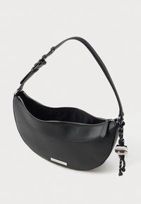 Fekete, félhold alakú táska állítható pánttal, ezüst cipzárral, fém logólappal és napszemüveget viselő kis baba kulcstartóval. 