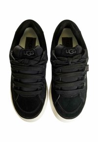 Sneakers in pelle scamosciata nera con punta arrotondata, dotate di lacci neri e suola in gomma bianca. Logo UGG sulla linguetta. Tomaia strutturata.