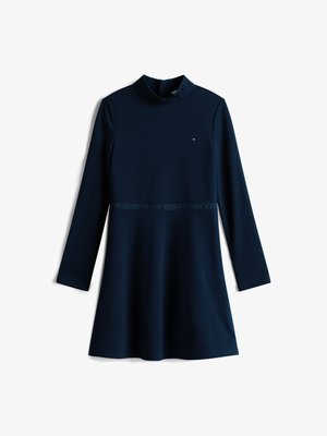 Tengerészkék hosszú ujjú ruha, magas nyakkal, bővülő szoknyával és logó részlettel a deréknál. Puha, sima anyagból készült.