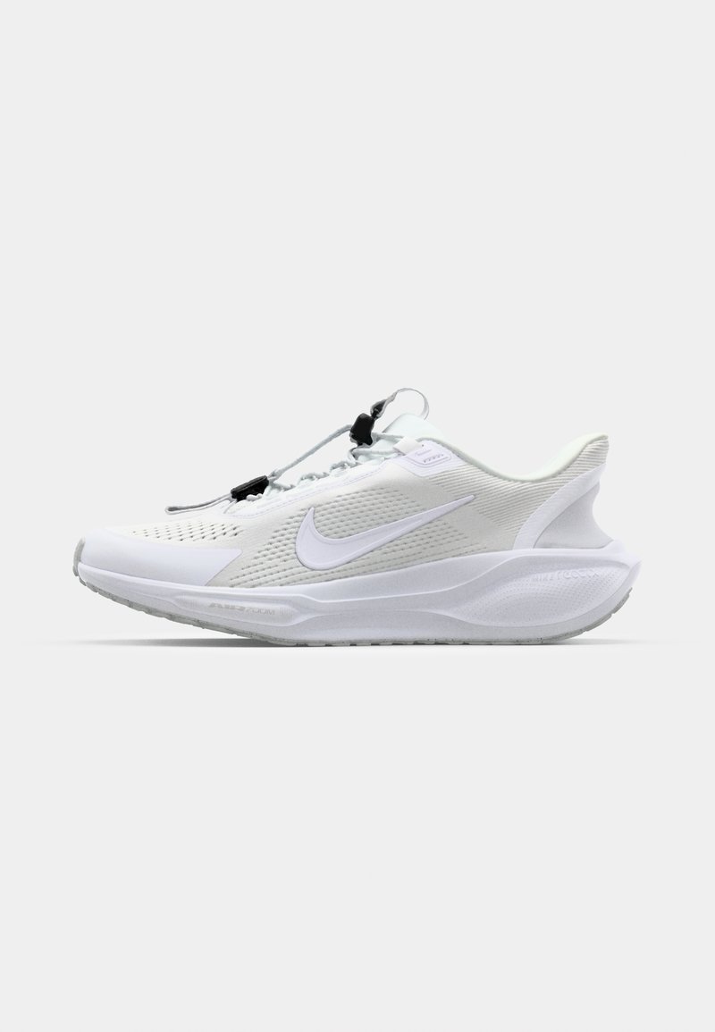 Zapatilla deportiva blanca con parte superior de malla, lados texturizados y suela acolchada. Presenta cordones elásticos y un distintivo logo tipo swoosh.