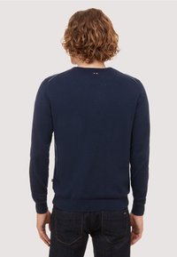 Pull en maille bleu marine avec col rond, poignets et ourlet côtelés, orné d'un petit logo à l'arrière près du col.