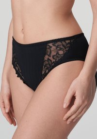 Hoge taille zwarte panties gemaakt van stof met mesh kanten zijpanelen. Kenmerkt zich door een bloemenpatroon en decoratieve golvende randen.