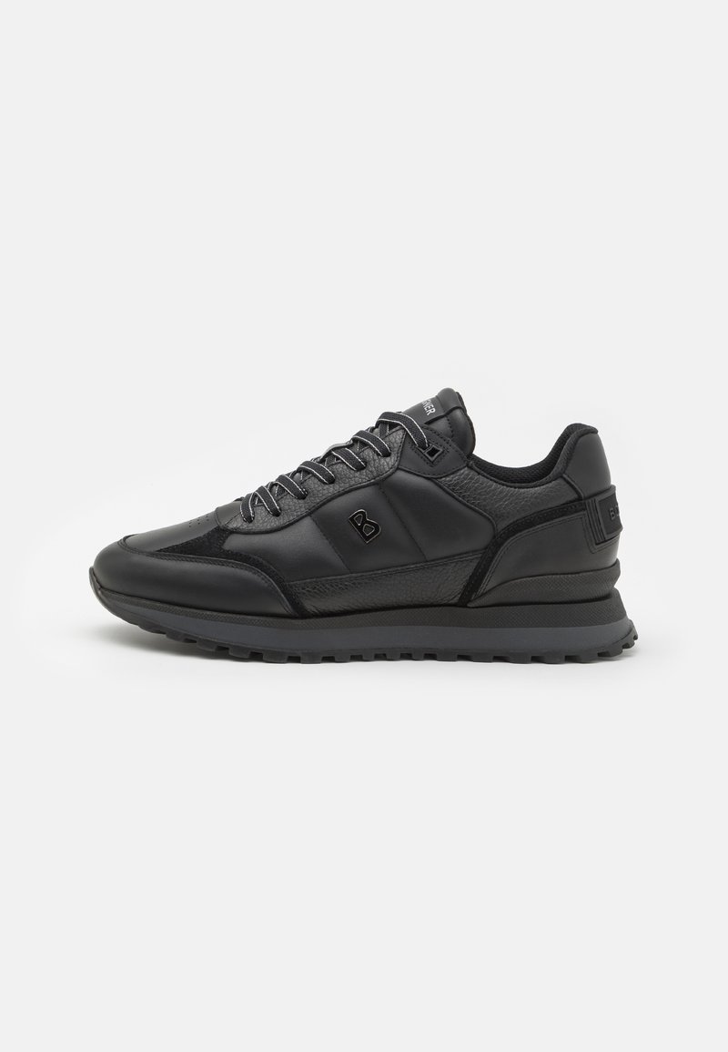 Black sneakers featuring a mix of smooth and textured materials, rounded toe, lace-up design, and a raised, durable sole.