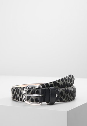 Ceinture en cuir avec motif léopard noir et gris, boucle en métal argenté et boucle en cuir noir, présentée enroulée sur une surface blanche.