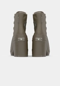 Brown winter boots with a chunky platform, textured material, and multiple side eyelets. Features a raised star logo and "water resistant" label.