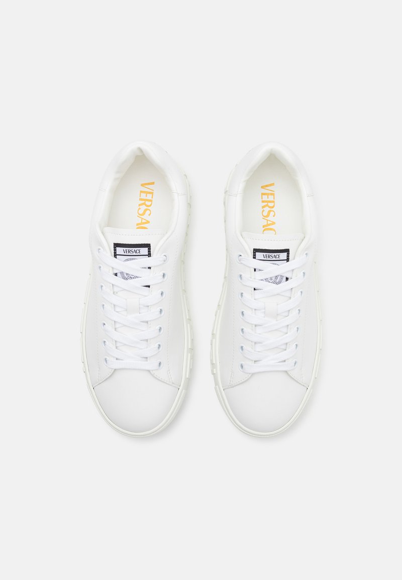 Witte leren sneakers met ronde neuzen, platte veters en rubberen zolen. Beschikt over een merk-inlegzool en een label bij de tong.