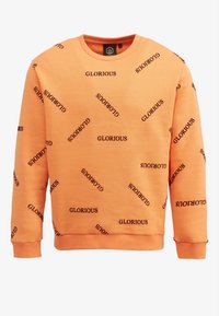 Sudadera naranja con cuello redondo y mangas largas, que presenta un texto repetido en negro "GLORIOUS" en varios ángulos y un dobladillo acanalado.