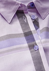 Camisa de cuadros morados con cuello, que presenta rayas negras y púrpuras claras, y botones contrastantes. Tejido texturizado con un ligero brillo.