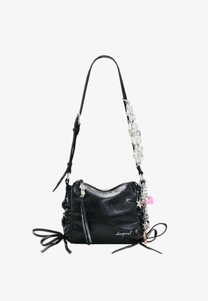Sac à bandoulière en cuir noir avec sangle réglable, détails nœuds sur les côtés, breloques florales argentées, porte-clés en forme d’étoile et de cœur, et fermeture éclair.