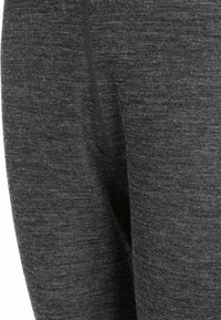 Mörkgrå leggings med en texturerad yta, med en ton-i-ton söm och elastisk midja. Tyg verkar vara stretchigt och bekvämt.