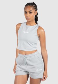 Szary sportowy top w stylu crop oraz szorty wykonane z miękkiej mieszanki bawełny, z małym białym logo. Prosty design z luźnym krojem i elastycznym pasem.