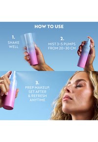 Mains tenant un flacon spray rose et violet montrant les étapes : bien agiter, vaporiser 3 à 5 pulvérisations à 20-30 cm, vaporiser sur le visage pour préparer ou rafraîchir le maquillage.