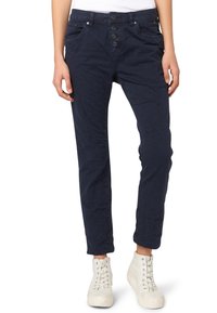 Mörkblå, avsmalnande byxor med femknaps gylf, framfickor och synliga sömnadsdetaljer. Tillverkade av mjukt, texturerat tyg; stiliserade på ett avslappnat sätt.