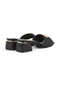 Sandalias tejidas negras con un tacón grueso y texturizado. Cuenta con un acento dorado en la parte superior. Forro interior suave y diseño de parte trasera abierta.