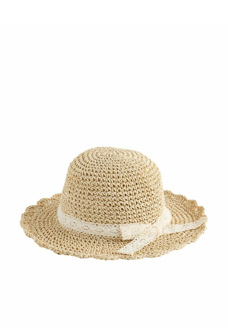 Chapeau en paille avec un large bord en forme de vagues, de couleur beige. Présente un design tissé texturé et un ruban en dentelle décoratif noué autour de la base.