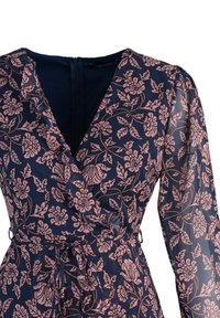 Robe portefeuille bleu marine avec motif floral rose, manches longues transparentes, encolure à volants et ceinture à nouer à la taille.