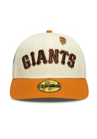 Gorra blanca de béisbol con bordado marrón que dice "GIANTS", visera naranja y emblema de logo lateral. Tela texturizada con diseño de visera plana.