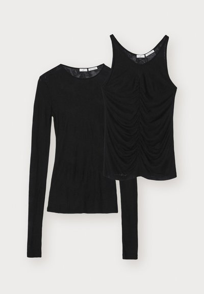 Demonstruojami du juodi viršūnės: ilgomis rankovėmis mėlyna ir be rankovių viršūnė su surinktu detalizavimu priekyje. Abu pagaminti iš minkštos medžiagos.