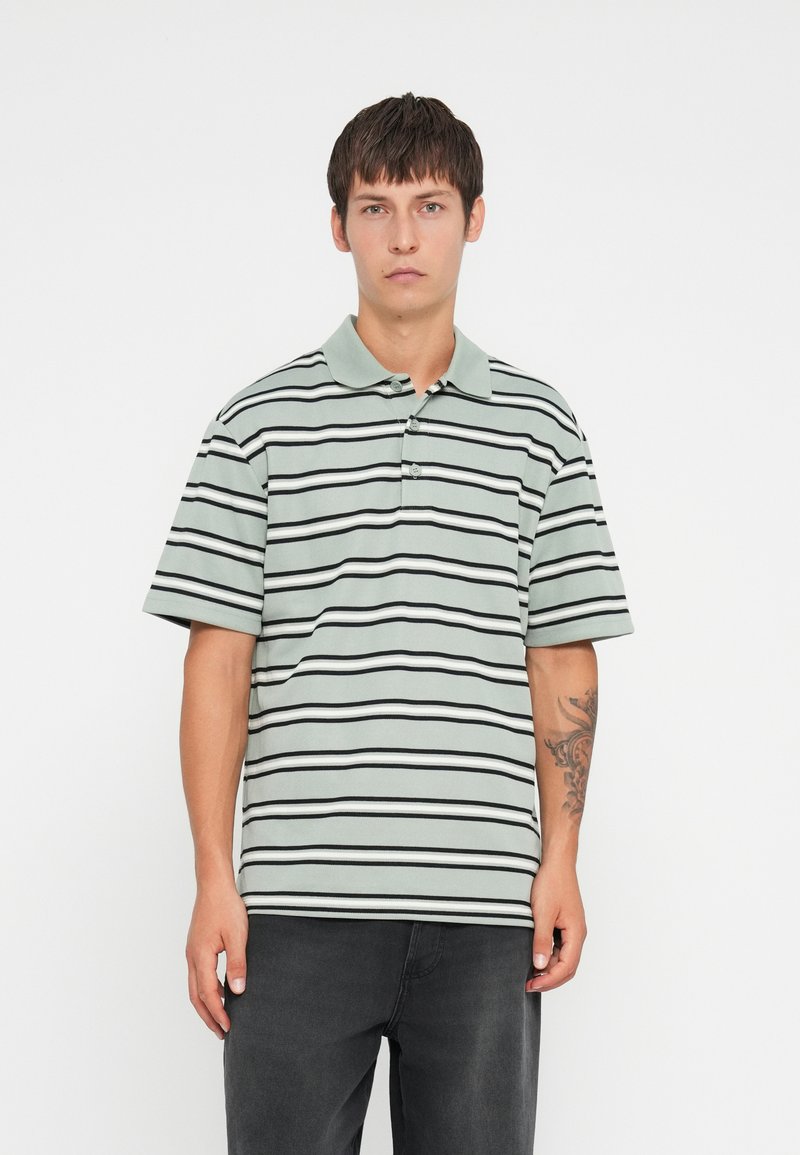 Stripete polo-skjorte i mintgrønn med svarte og hvite horisontale striper, kortermet, og med krage og tre knapper.