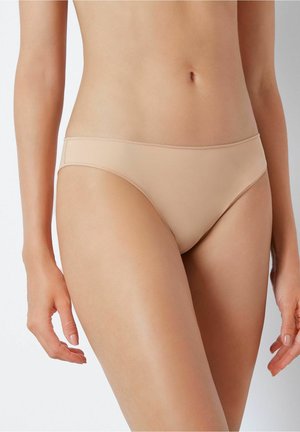 Naadloze beige bikinionderkant met een lage snit, een gladde textuur en minimale stikdetails, ontworpen voor comfort en een discrete pasvorm.