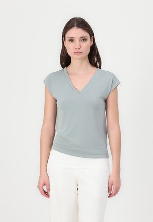 Lys grå, kortermet V-hals t-skjorte laget av mykt materiale, med en avslappet passform og minimalistisk design, paret med hvite bukser.