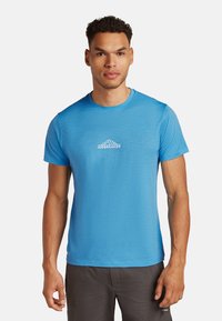Camiseta atlética de manga corta azul con cuello redondo y textura suave. Presenta un logo blanco de "Icebreaker" y un sutil diseño de montaña.