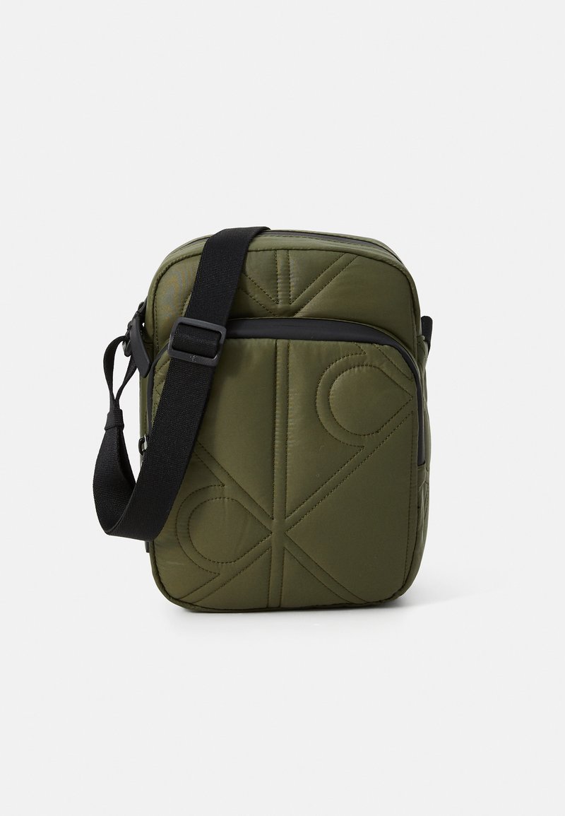 Olivengrøn crossbody taske med quiltet mønster, sort rem, rektangulær form og lynlås. Tekstureret stof med diskret logo-detail.