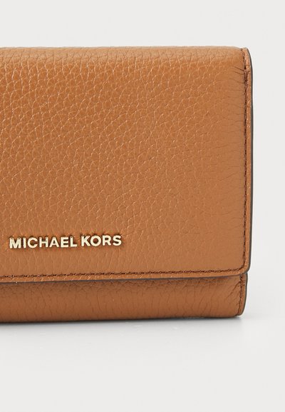 Portefeuille en cuir tan avec une surface texturée, présentant un logo doré. Forme rectangulaire compacte avec des bords cousus et un design pliant.