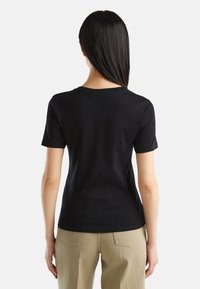 Czarny krótki rękaw t-shirt wykonany z miękkiej bawełny, z zaokrąglonym dekoltem i dopasowanym krojem. Gładka tekstura z minimalnymi detalami.