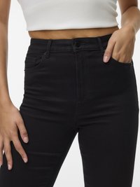 Czarne jeansy z wysokim stanem o dopasowanym kroju, wyposażone w przednie kieszenie i zapięcie na guzik w pasie. Gładka faktura, bez widocznych wzorów.