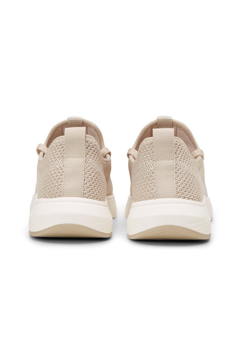 Beżowe dziane sneakersy z fakturowanym wierzchem, okrągłym czubkiem i białą gumową podeszwą. Posiadają pętle z tyłu, ułatwiające zakładanie.
