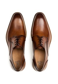 Bruine leren dresschoenen met een gladde afwerking, voorzien van een ronde neus, vijf oogjes en een slank vetersysteem.