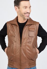 Braune Lederweste mit einem Frontreißverschluss, zwei Seitentaschen, einer Brusttasche und einem gerippten Bund. Glatte Textur und strukturiertes Design.