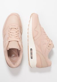 Světlé růžové tenisky z kůže a semiše, zaoblený tvar, zavazování na tkaničky, vybavené vzduchovou odpruženou vložkou a podrážkou z texturované gumy.